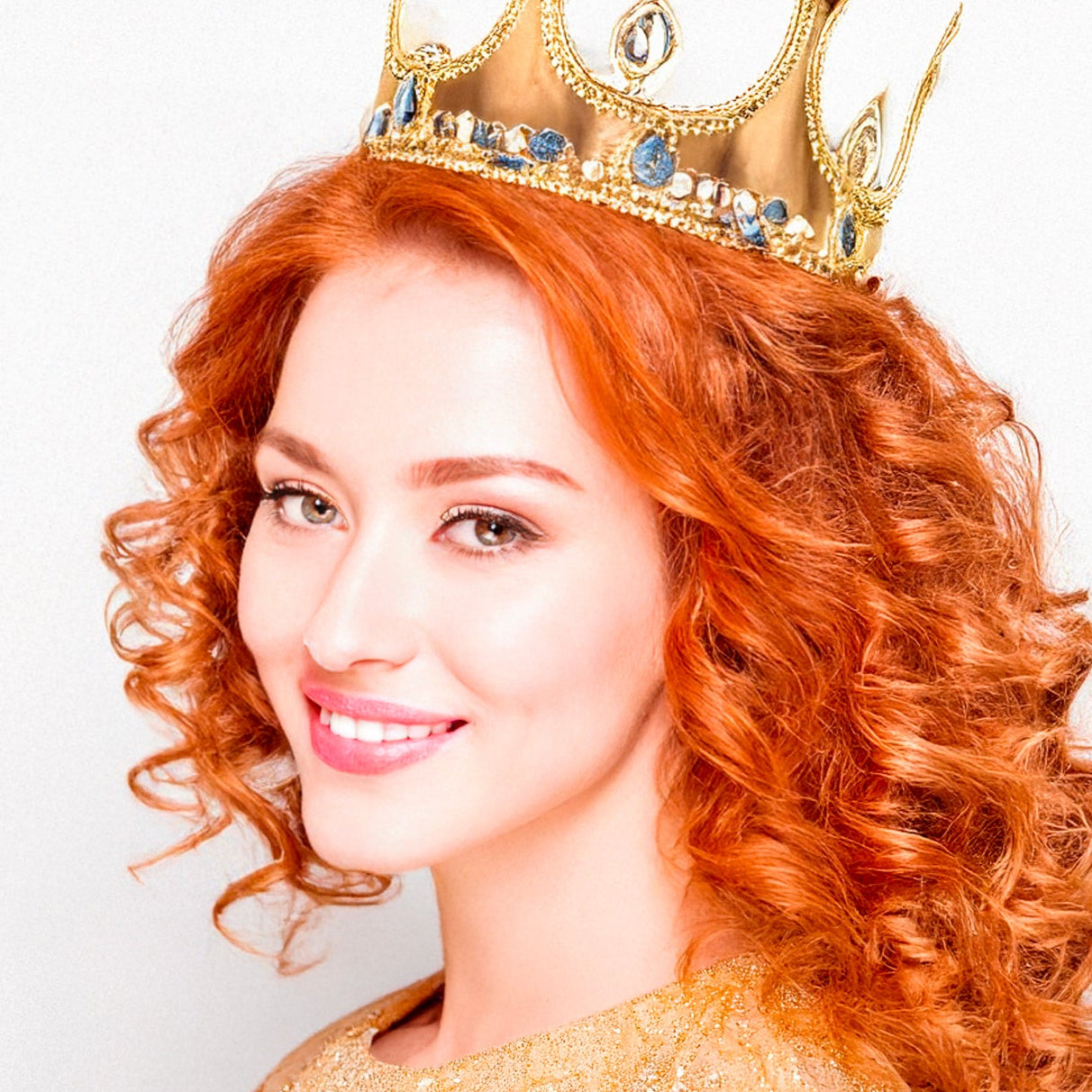 Woman with red hair wearing a gold crown and dress on a white background